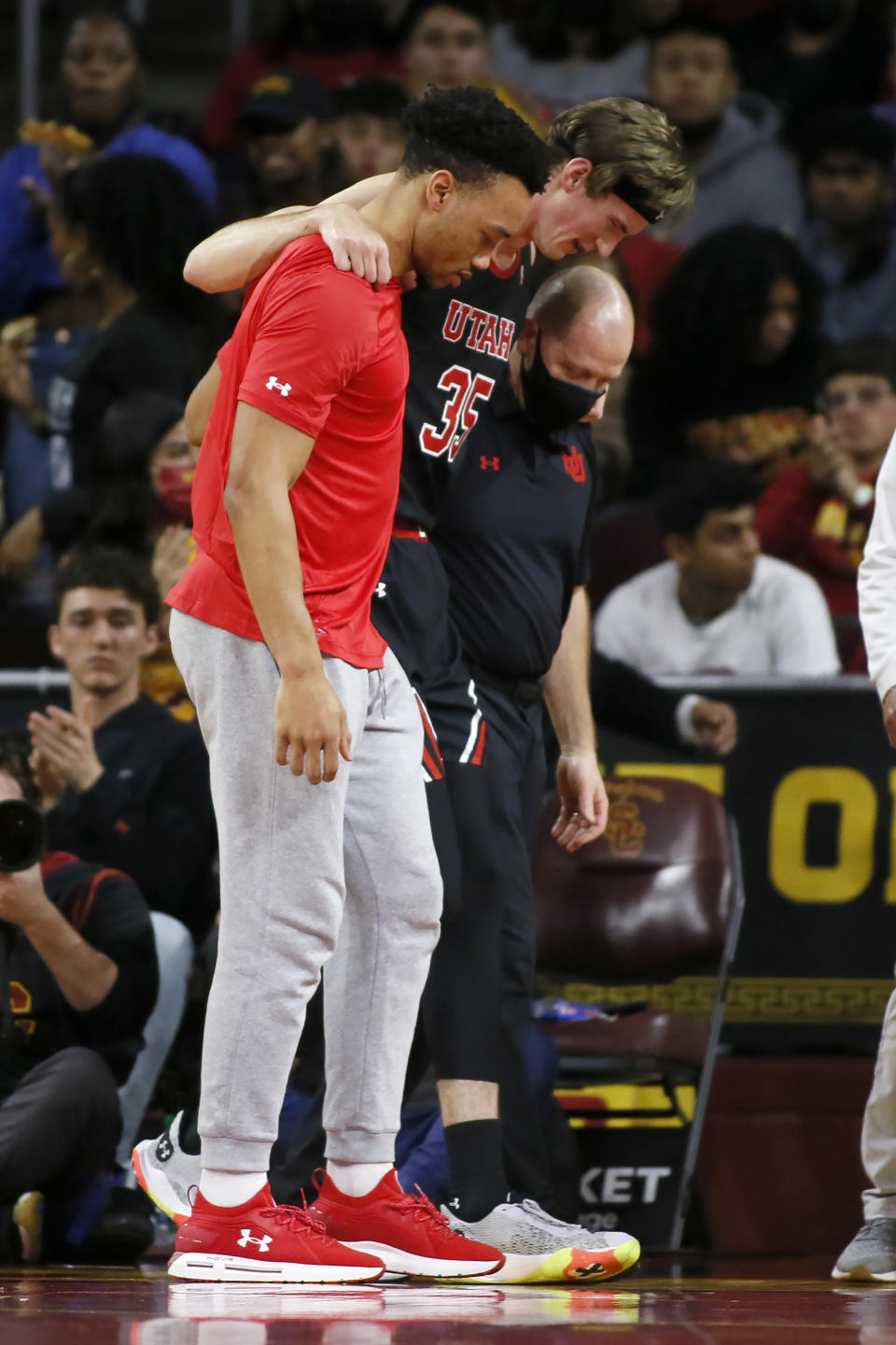 Utah center Branden Carlson (35) is helped off the court during the first half of the team's NCAA college basketball game against Southern California in Los Angeles, Wednesday, Dec. 1, 2021. (AP Photo/Alex Gallardo)