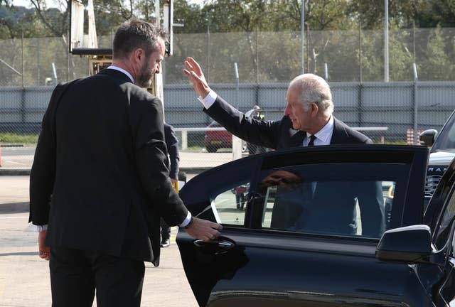 King Charles III waves to onlookers as he arrives at Belfast City Airport