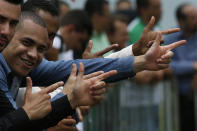 FILE - Supporters of Brazil's President Jair Bolsonaro flash finger-gun gestures at the launch of Bolsonaro's new political party, Alliance for Brazil, in Brasilia, Brazil, Nov. 21, 2019. With the Oct. 2, 2022 election just three months off, some polls show only one in five women will vote for the tough-talking, pro-gun, motorcycle-riding former Army captain Bolsonaro. Almost half of Brazilian women say they will vote for the president’s opponent. (AP Photo/Eraldo Peres, File)