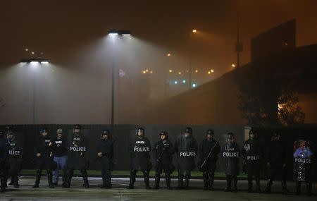 Police in riot gear stand by as protesters march through the streets during the early hours of the morning in St. Louis, Missouri October 13, 2014. REUTERS/Jim Young