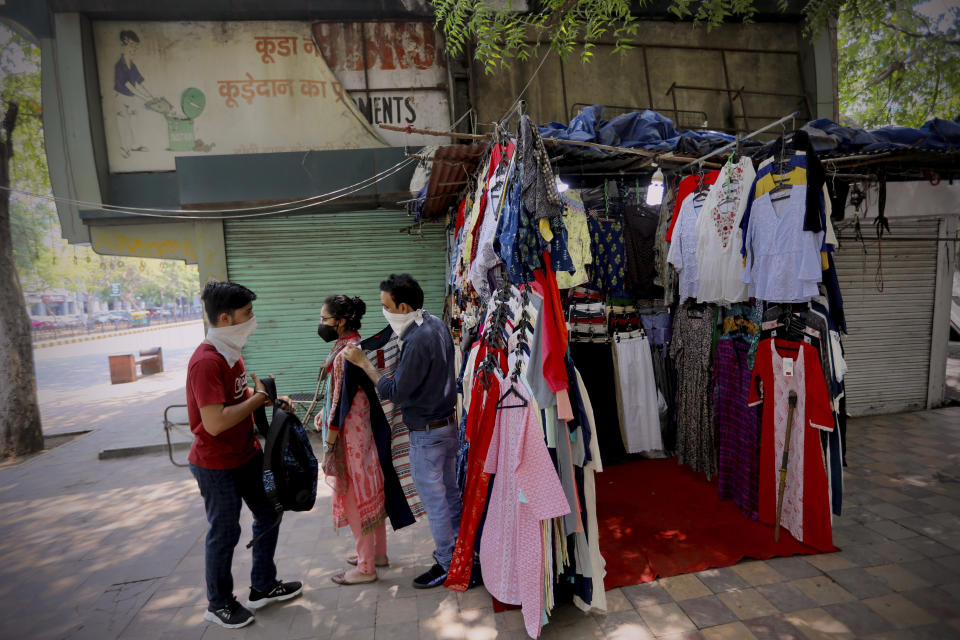 People shop for clothes at the Janpath market in New Delhi, India, Monday, June 1, 2020. More states opened up and crowds of commuters trickled onto the roads in many of India's cities on Monday as a three-phase plan to lift the nationwide coronavirus lockdown started despite an upward trend in new infections. (AP Photo/Manish Swarup)