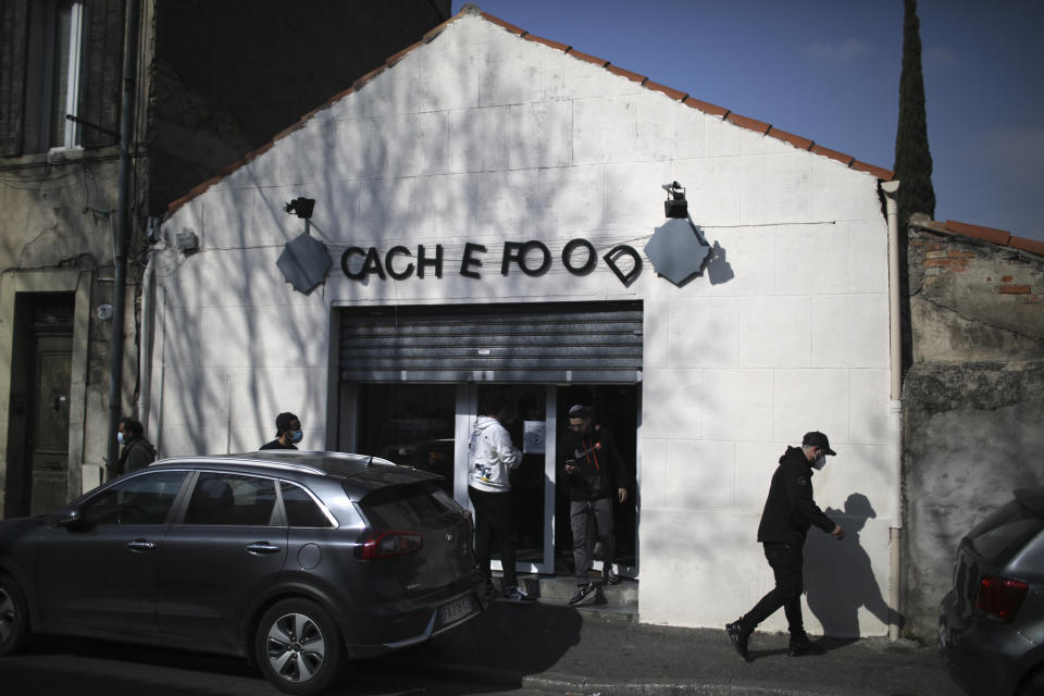 People gather outside kosher market after a man visibly brandished a knife outside a Jewish school and a kosher market in Marseille, southern France, Friday, March 5, 2021. Police detained a man Friday who was wielding a knife outside a Jewish school and kosher market, and increased surveillance of Jewish sites in the city while they investigate his motives, according to local authorities. (AP Photo/Daniel Cole)