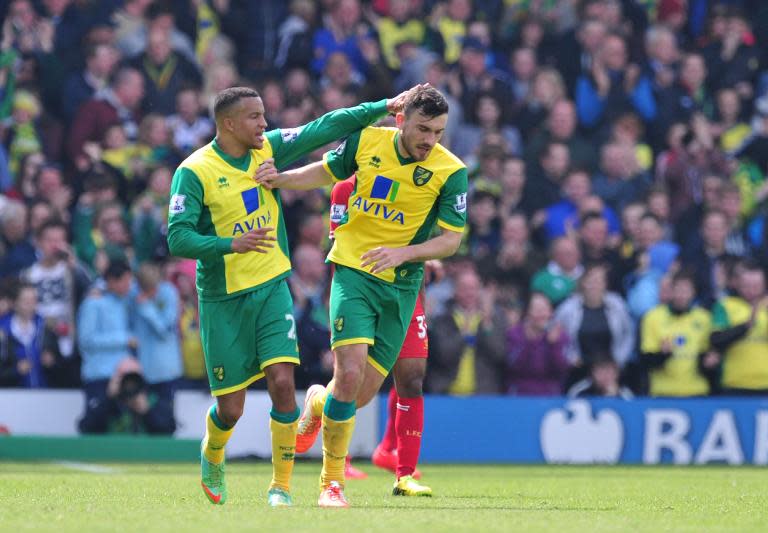 Norwich City midfielder Robert Snodgrass (R) is congratulated by midfielder Russell Martin after he scored the team's second goal against Liverpool at Carrow Road in Norwich on April 20, 2014