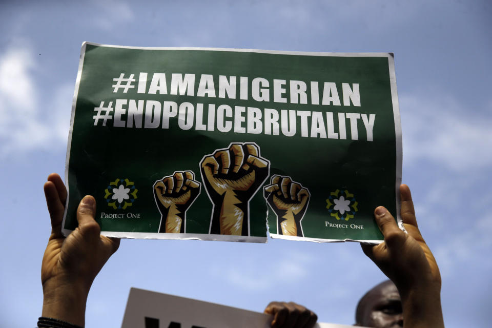 People hold banners as they demonstrate on the street to protest against police brutality in Lagos, Nigeria, Thursday Oct. 15, 2020. Protests against Nigeria's police continued to rock the country for the eighth straight day Thursday as demonstrators marched through the streets of major cities, blocking traffic and disrupting business. (AP Photo/Sunday Alamba)