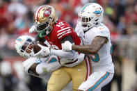 San Francisco 49ers wide receiver Deebo Samuel (19) runs between Miami Dolphins safety Jevon Holland, left, and cornerback Xavien Howard during the second half of an NFL football game in Santa Clara, Calif., Sunday, Dec. 4, 2022. (AP Photo/Jed Jacobsohn)
