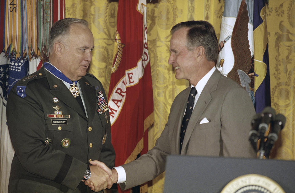 FILE - President George H.W. Bush congratulates Desert Storm commander Gen. Norman Schwarzkopf after presenting him with the medal of freedom at the White House in Washington, July 4, 1991. Bush also bestowed the medal on Joint Chiefs of Staff Chairman Gen. Colin Powell. (AP Photo/Doug Mills, File)