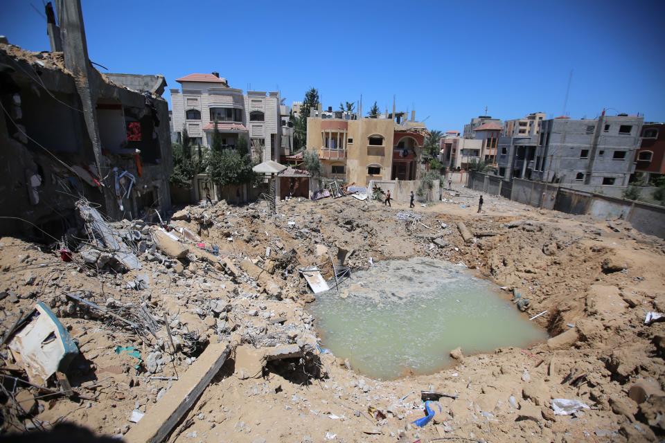 GAZA CITY, GAZA - MAY13: Palestinians search their belongings as rescue efforts continue to evacuate Palestinians from the rubble of the buildings destroyed by ongoing Israeli airstrikes on Gaza, at Al Bureij refugee cam in Gaza City, Gaza on May 13, 2021. Palestinians in Gaza Strip observe Eid al-Fitr that marks the end of the holy month of Ramadan, under Israeli airstrikes on Gaza. (Photo by Hassan Jedi/Anadolu Agency via Getty Images)