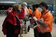 A security officer checks a fan arriving for an NCAA College Football Playoff national championship game between Alabama and Ohio State Monday, Jan. 11, 2021, in Miami Gardens, Fla. (AP Photo/Lynne Sladky)