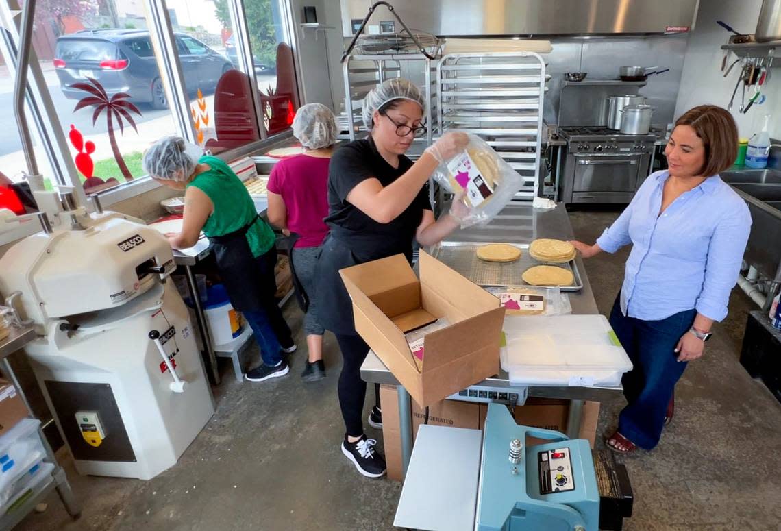 Anais Garcia packs a box of fresh tortillas at Yoli Tortilleria’s West Side storefront as owner Marissa Gencarellia looks on.