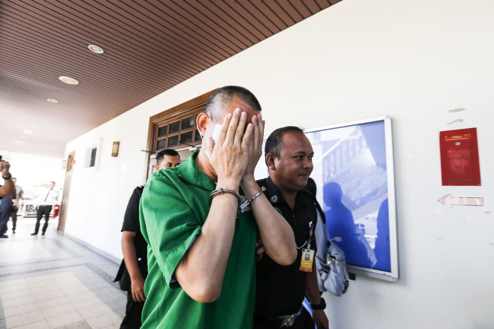 Chinese national Wang De Qun, 58, is escorted to the Penang High Court in George Town October 30, 2019. — Picture by Sayuti Zainudin