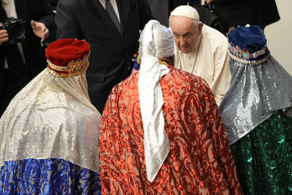 El papa Francisco habla con fieles vestidos como los Reyes Magos, al final de su audiencia general en el Salón de Pablo VI del Vaticano, el miércoles 21 de diciembre de 2022. (AP Foto/Andrew Medichini)