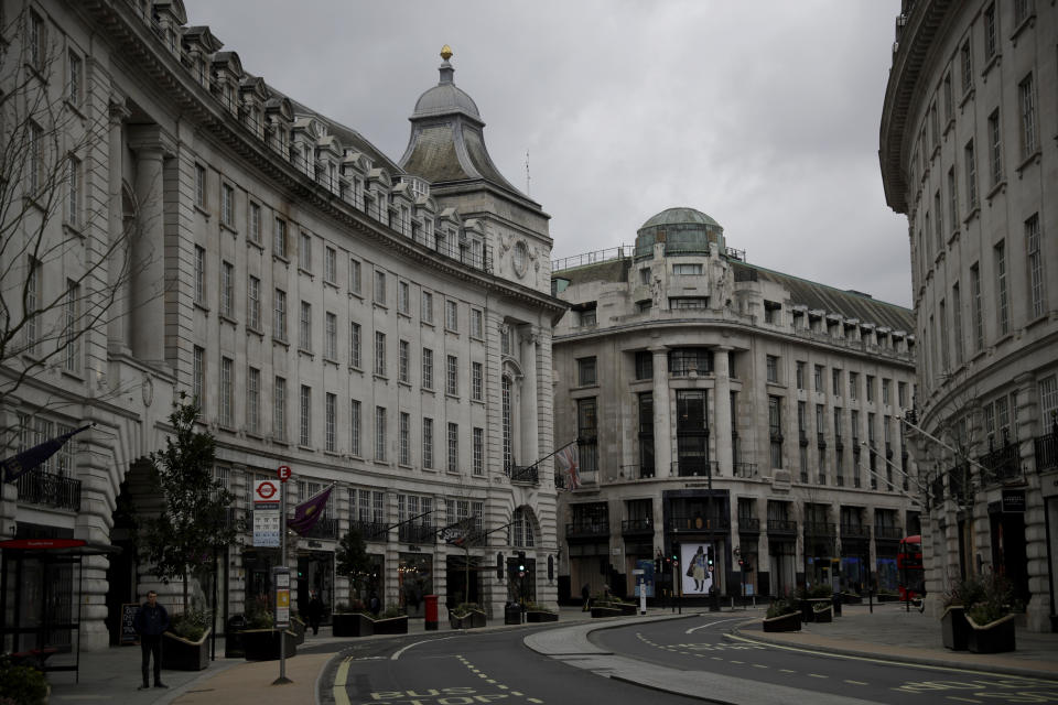 A quiet Regent Street in central London, where non-essential shops are temporarily closed during England's third coronavirus lockdown, Friday, March 26, 2021. The pandemic has battered the British economy, which has suffered its deepest recession in more than 300 years. Pubs, restaurants, theaters, hair salons and all stores selling nonessential items such as books and footwear have spent much of the past year closed. (AP Photo/Matt Dunham)