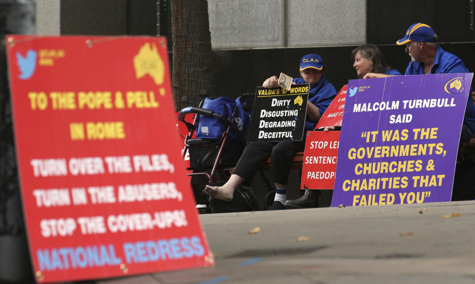 FILE - In this March 1, 2016 file photo, a group gathers to protest with placards outside an inquiry into child sex abuse in Sydney. Pope Francis' high-stakes sex abuse prevention summit is meant to call attention to the crisis as a global problem that requires a global response. Australia's Catholic Church has a horrific abuse record, which in part prompted the government to launch a four-year national investigation into all forms of institutional abuse — Catholic and otherwise. (AP Photo/Rick Rycroft, file)