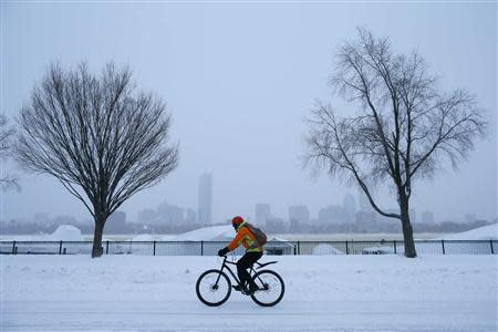 A cyclist rides along snow covered Memorial Drive during a winter nor'easter snow storm in Cambridge, Massachusetts January 3, 2014. REUTERS/Brian Snyder