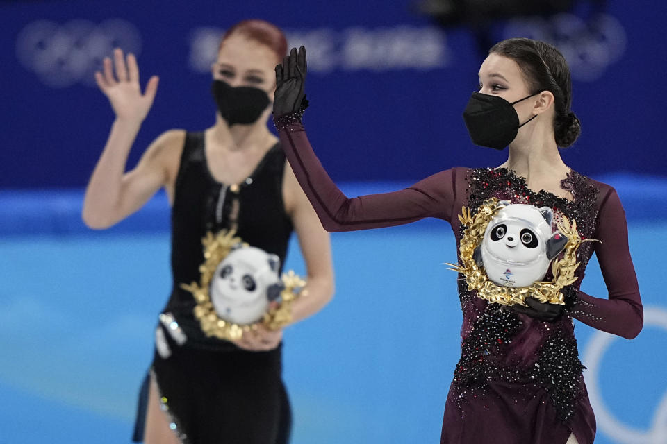 Gold medalist Anna Shcherbakova, right, of the Russian Olympic Committee,waves as she walks with silver medalist and compatriot Alexandra Trusova, left, following the women's free skate program during the figure skating competition at the 2022 Winter Olympics, Thursday, Feb. 17, 2022, in Beijing. (AP Photo/David J. Phillip)