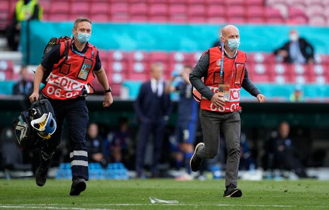 Paramedics rush onto the field to treat Eriksen 