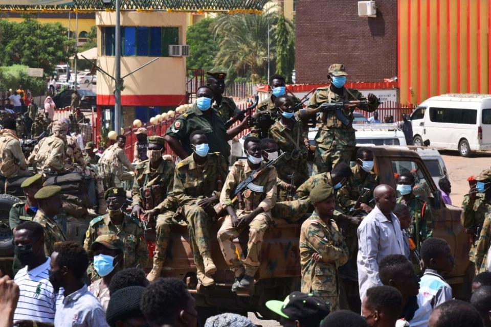 Sudanese security forces keep watch as they protect a military hospital and government offices after the military declared a state of emergency. Source: Getty