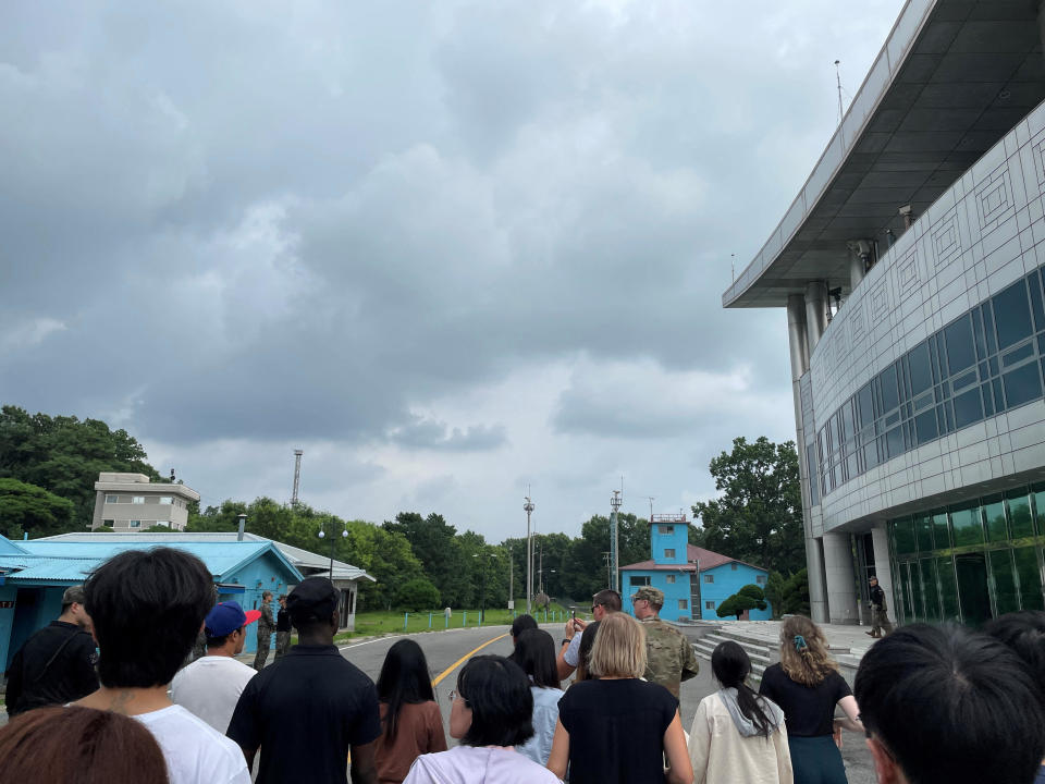 U.S. Private 2nd Class Travis King, wearing a black shirt and black cap at left, is seen in a picture taken during a tour of the tightly controlled Joint Security Area on the border between North Korea and South Korea, at the 