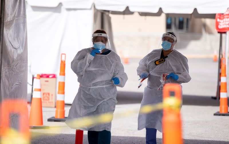 FILE PHOTO: Medical personnel dispense free Covid-19 tests in El Paso