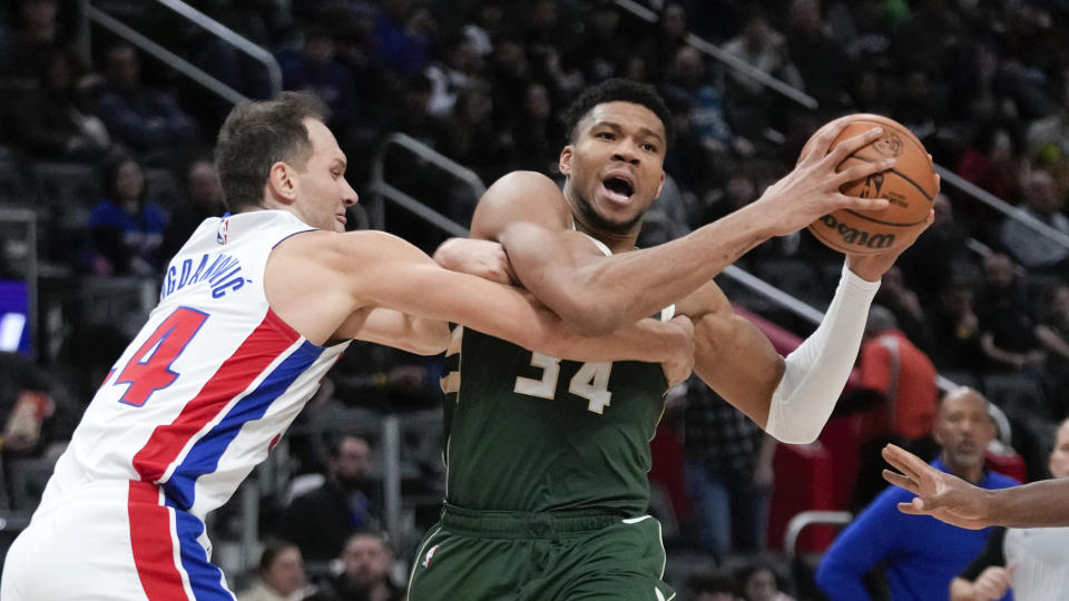 Milwaukee Bucks forward Giannis Antetokounmpo, right, is fouled by Detroit Pistons forward Bojan Bogdanovic, left, in the first half of an NBA basketball game in Detroit, Monday, Jan. 22, 2024. (AP Photo/Paul Sancya)