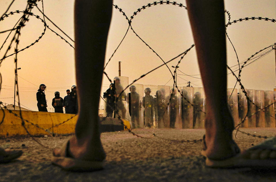 Anti-government protesters gather while Security forces surround the protest site during ongoing protests in Basra, Iraq, Wednesday, Nov. 4, 2020. (AP Photo/Nabil al-Jurani)