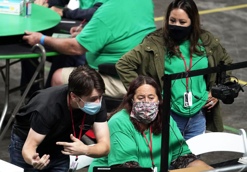 Maricopa County ballots cast in the 2020 general election are being examined and recounted by contractors working for Florida-based company, Cyber Ninjas, who was hired by the Arizona State Senate at Veterans Memorial Coliseum in Phoenix, Thursday, April 29, 2021. (Rob Schumacher/The Arizona Republic via AP, Pool)