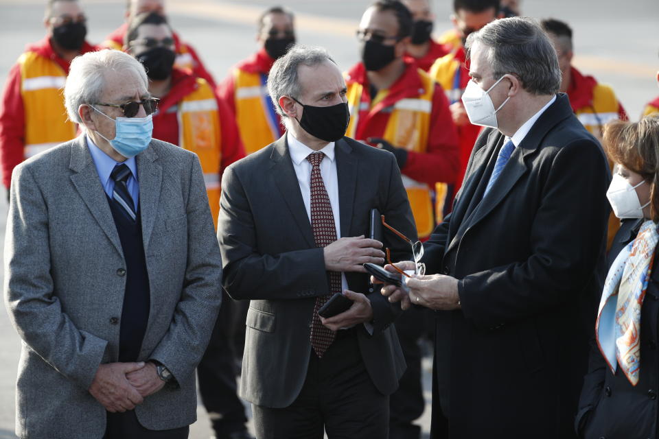 Mexico's Health Secretary Jorge Alcocer, left, coronavirus response leader Hugo López-Gatell, center, and Foreign Minister Marcelo Ebrard wait for the arrival of the first shipment of the Pfizer COVID-19 vaccine at the Benito Juarez International Airport in Mexico City, Wednesday, Dec. 23, 2020. (AP Photo/Eduardo Verdugo)