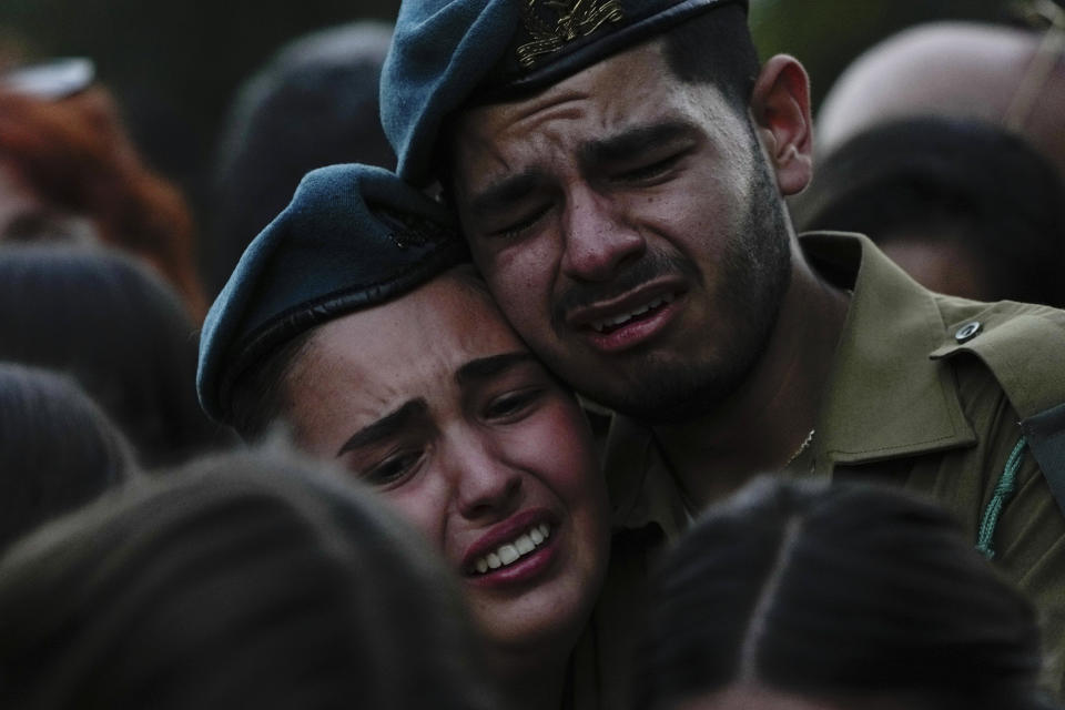 FILE - Israeli soldiers cry during the funeral of Sgt. Yam Goldstein and her father, Nadav, in Kibbutz Shefayim, Israel on Oct. 23, 2023. Yam and her father were killed by Hamas militants on Oct. 7 at their house in Kibbutz Kfar Azza near the border with the Gaza Strip. More than two weeks after Hamas' attack, many Israelis are furious at Prime Minister Benjamin Netanyahu's government, not just for failing to prevent the initial attack, but for failing to come to their aid afterward. While the military is bombing Gaza and preparing a possible invasion, Israeli government infighting and the erosion of the civil service have left traumatized survivors to mourn on their own. (AP Photo/Ariel Schalit, File)