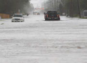 Cars sit stalled on a flooded Sale Road during heavy rains in Lake Charles, La., Monday, May 17, 2021. (Rick Hickman/American Press via AP)