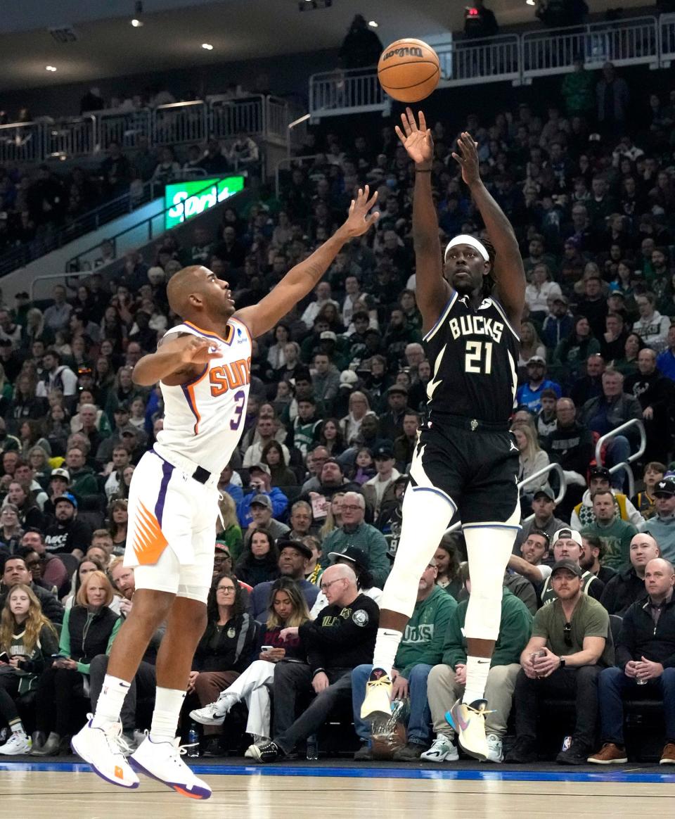 Milwaukee Bucks guard Jrue Holiday hits a shot over Phoenix Suns guard Chris Paul during the first half of their game at Fiserv Forum.