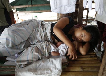 An evacuee breastfeeds her baby at a temporary shelter for earthquake victims in Loay, Bohol October 17, 2013. REUTERS/Erik De Castro
