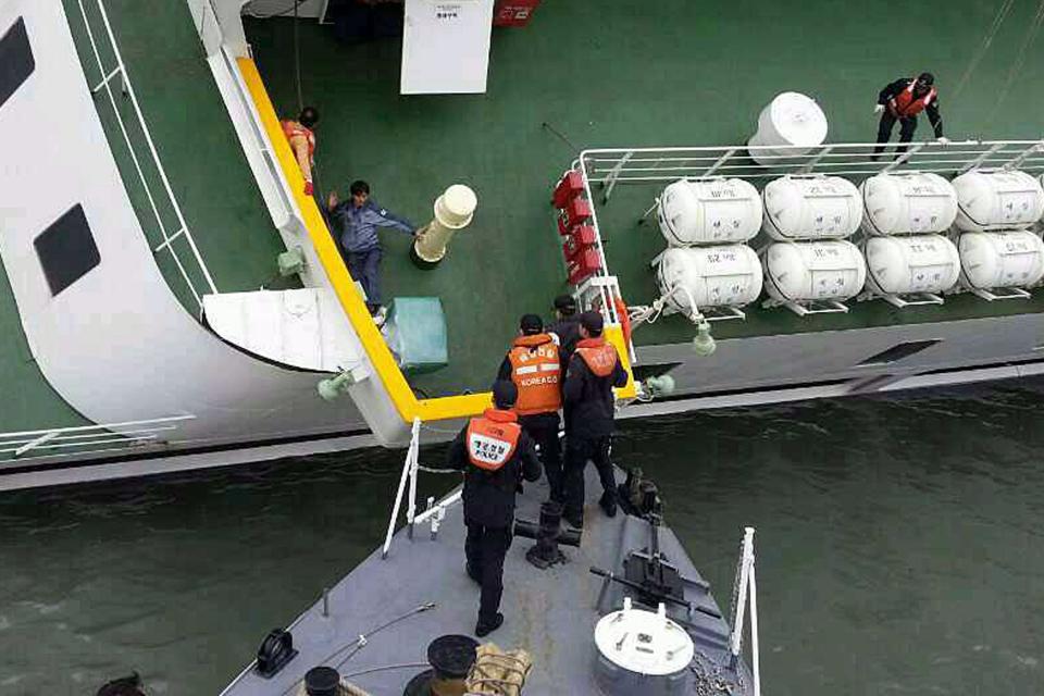 A passenger is rescued by South Korean maritime policemen from a sinking ship "Sewol" in the sea off Jindo April 16, 2014, in this picture provided by Korea Coast Guard and released by Yonhap. More than 100 people remained missing on Wednesday after a South Korean ferry with 477 people aboard capsized off the country's southwest coast, Yonhap news agency said. REUTERS/Korea Coast Guard/Yonhap