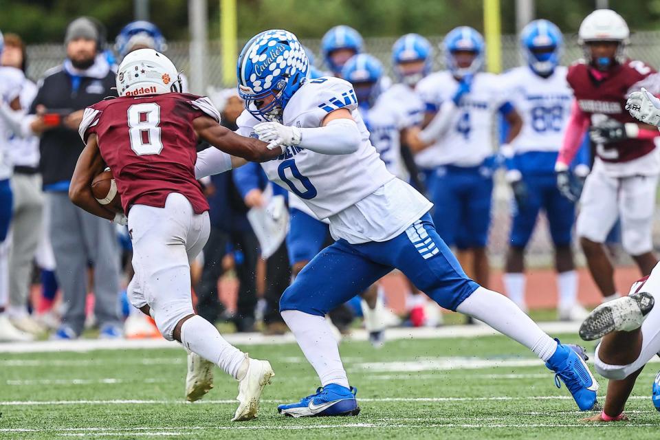 Middletown Cavaliers linebacker Ryan VanKerkhoven (0) wraps up Mark Nelson (8) in the back field during a regular season game between Hodgson and Middletown Saturday, Oct. 14, 2023, at Bob Peoples Stadium on the campus of Caravel Academy in Bear, DE.