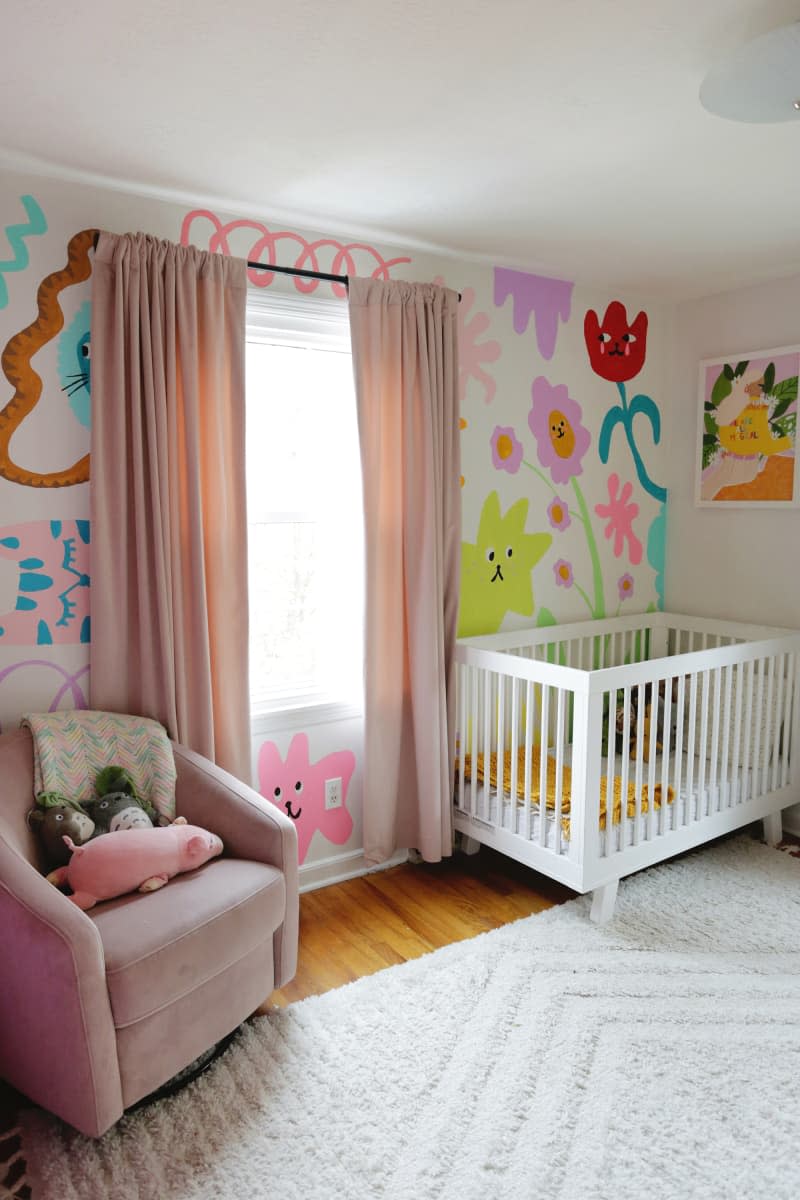 Floral mural painted behind crib in nursery.