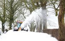 A farmer blows and ploughs the snow to clear roads which have cut off access to hospitals and supplies and hindered emergency workers in their effort to reach vulnerable people (PA)