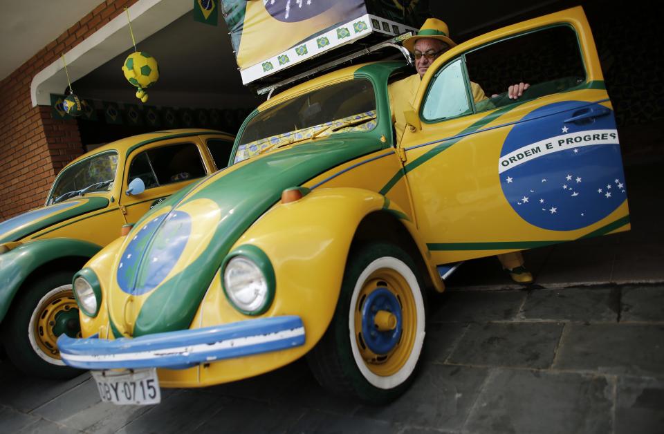 Brazilian attorney, Nelson Paviotti, gets into one of his two Volkswagen Beetles painted with the colors of the national flag in Campinas