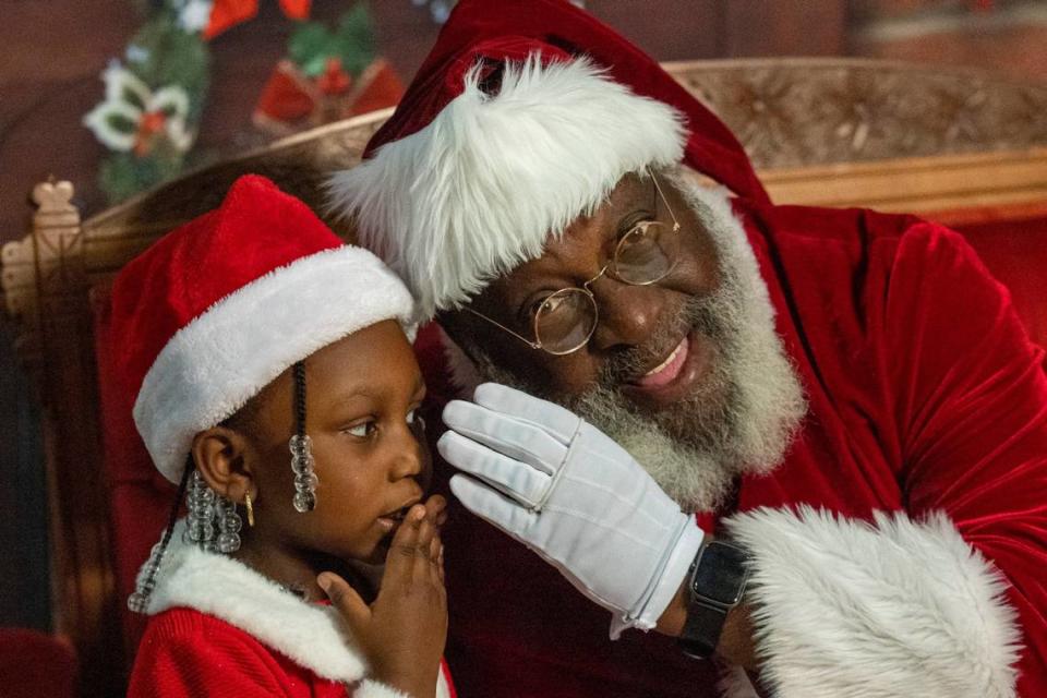 Nai’lah McCullers, 4, whispers her Christmas list while having her photograph made with “Santa Claus” at the Hayti Center in Durham Dec. 21, 2022.