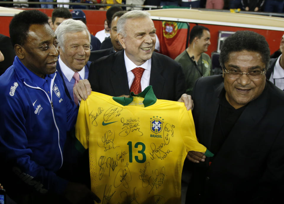 FILE - In this Sept. 10, 2013 file picture, Pele, left, New England Revolution owner Robert Kraft, second left, Brazil Football Federation President Jose Maria Marin, second right, and Eusebio pose with a Brazil soccer jersey prior to an international friendly soccer match between Portugal and Brazil, in Foxborough, Mass. Eusebio, the Portuguese football star who was born into poverty in Africa but became an international sporting icon and was voted one of the 10 best players of all time, has died of heart failure aged 71, Sunday Jan. 5, 2014. (AP Photo/Elise Amendola, File)