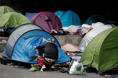 Migrants take their belongings as French police evacuate hundreds of migrants living in makeshift camp set up under the Porte de la Chapelle ring bridge in Paris, France, January 29, 2019. REUTERS/Benoit Tessier