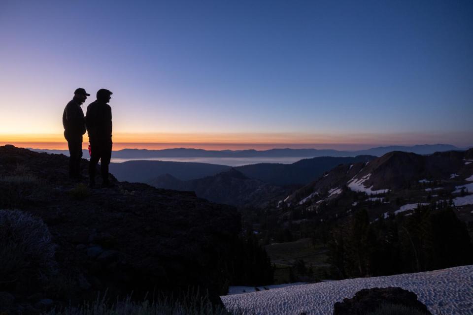 Spectators stand on the mountain before sunrise as they wait for runners to climb out of Olympic Valley