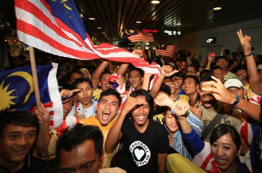 File picture. Malaysian football fans cheer as their victorious international football team arrive with the AFF Suzuki Cup trophy at Kuala Lumpur International Airport in December 2010. Southeast Asian champions Malaysia will be desperate to put a run of poor performances behind them when they begin the defence of their AFF Suzuki Cup football title this weekend