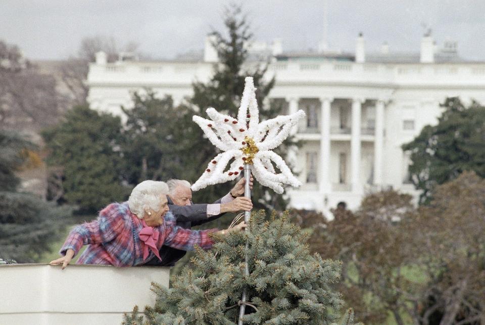 Barbara Bush places an ornament on top of the National Christmas Tree in 1984.