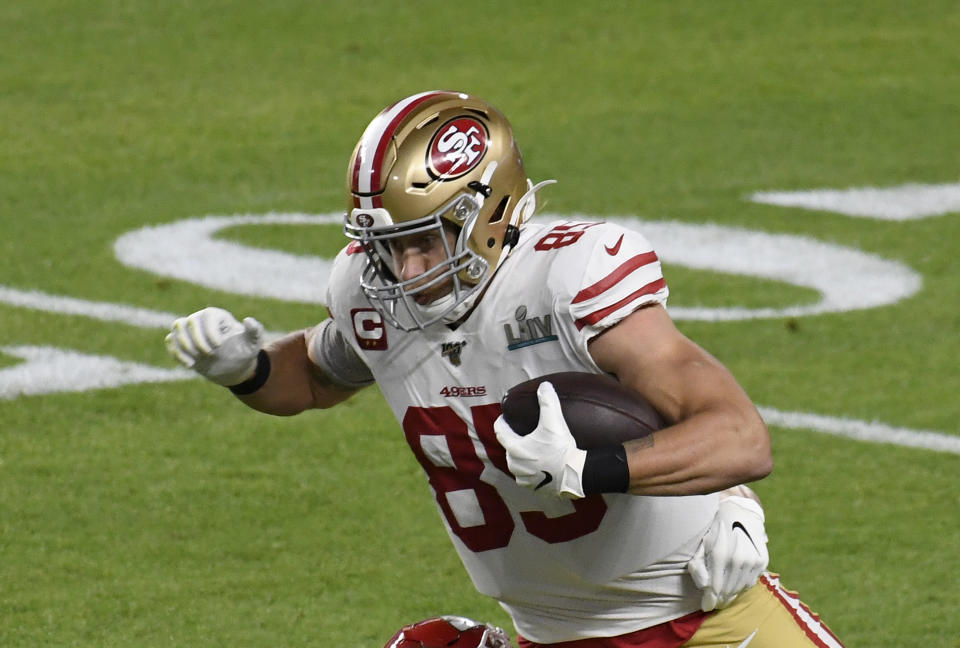 George Kittle runs with the ball in his arms.