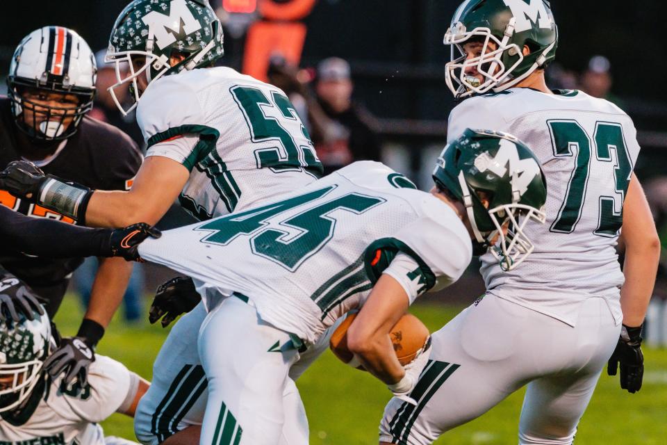 Malvern's Drake Hutchison gets his jersey held on a run play against Newcomerstown during week 8 high school football action, Friday, Oct. 6 at Lee Stadium in Newcomerstown, Ohio.