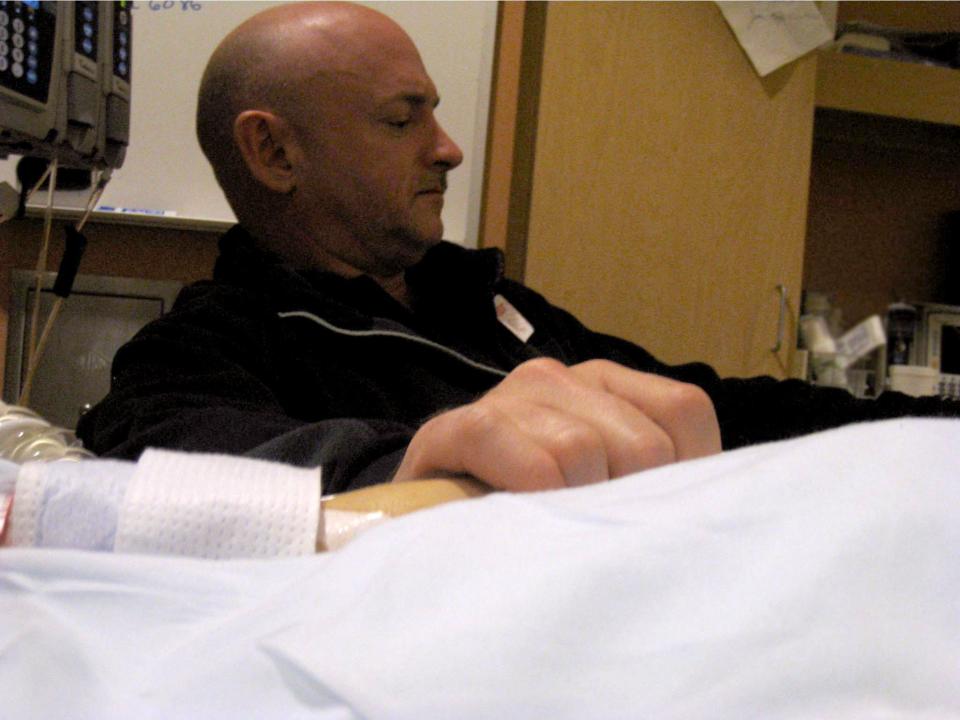 Mark Kelly holds Gabrielle Giffords' hand in her hospital room.