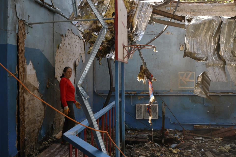 A sports teacher stands in a destroyed gymnasium of a school after Russian shelling in the village of Druzhkivka, Donetsk region, Ukraine, Monday, May 16, 2022. (AP Photo/Andriy Andriyenko)