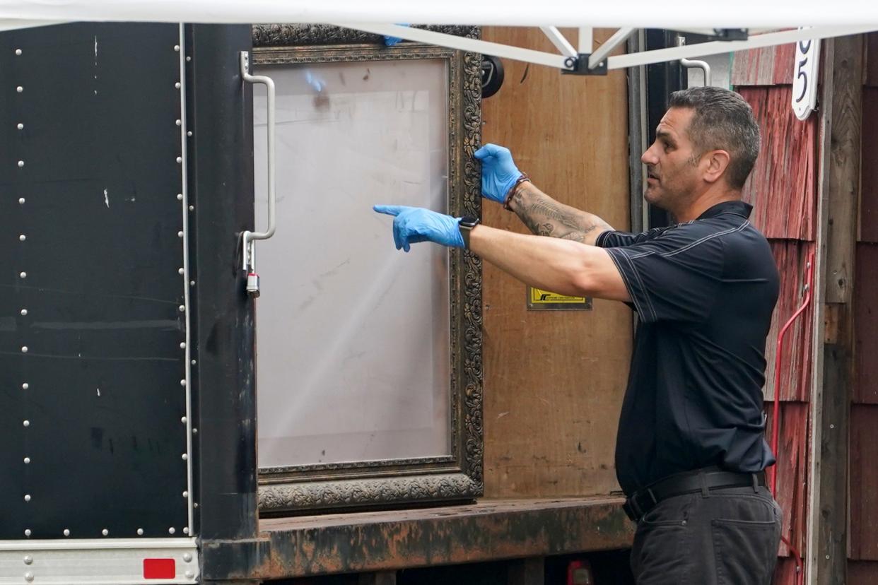 Authorities remove a picture frame as they search the home of suspect Rex Heuermann (Copyright 2023 The Associated Press. All rights reserved.)