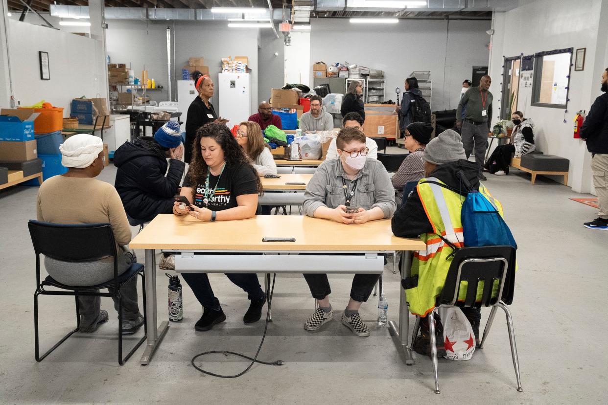 Volunteers (from left at front table) Julia Borland and Sarah Hanna work during a homeless survey they were conducting at The Open Shelter on Parsons Avenue.