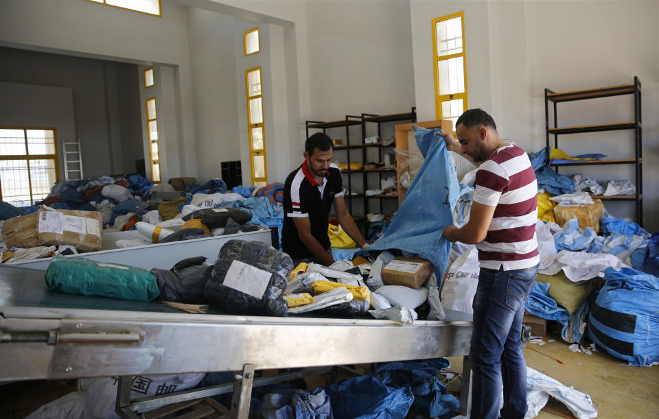 Palestinian postal workers sift through eight years' worth of undelivered mail held by Israel, at the post office in the West Bank city of Jericho, Sunday, Aug. 19, 2018. In recent days the postal staff has been sorting through tons of undelivered mail in a room packed with letters, boxes and even a wheelchair. Postal official Ramadan Ghazawi says Israel did not respect a 2008 agreement to send and receive mail directly through Jordan. Israeli officials say the one-time release of 10.5 tons of mail was a "gesture." (AP Photo/Nasser Shiyoukhi)