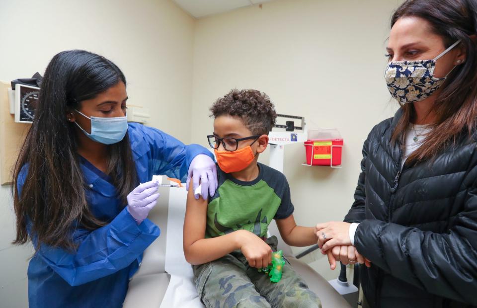 Meghan Miller, right, holds her son Julian Miller's hand as Public Health Nurse Nisha Kurian, left, administers the COVID-19 vaccination at Westchester County Department of Health in White Plains on Wednesday, November 10, 2021.